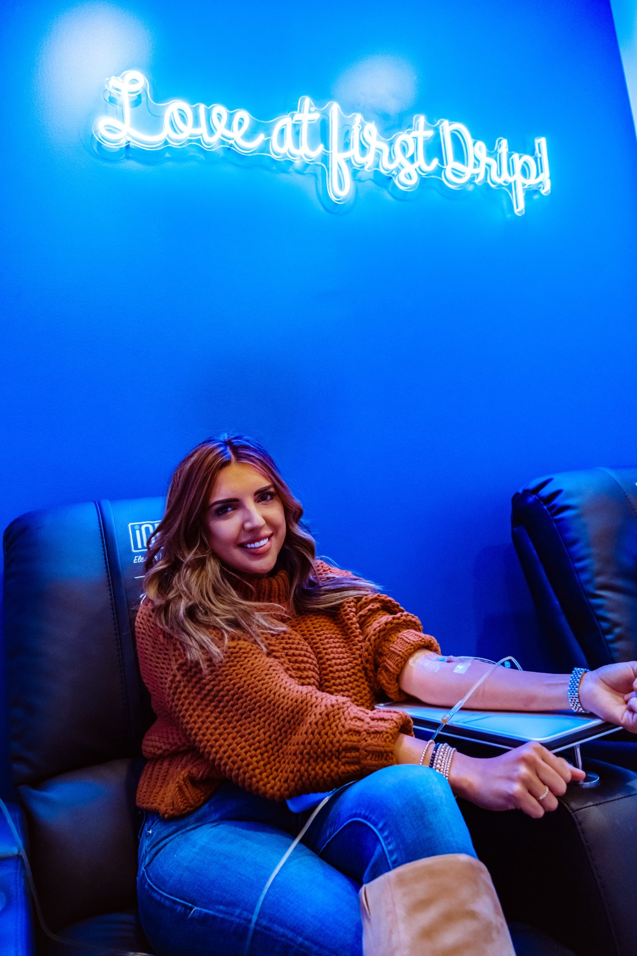 iCRYO Westminster guest receiving an IV drip under the Love at First Drip neon